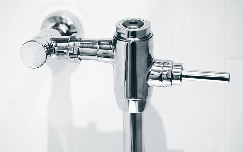 Chrome commercial toilet flush valve mechanism.