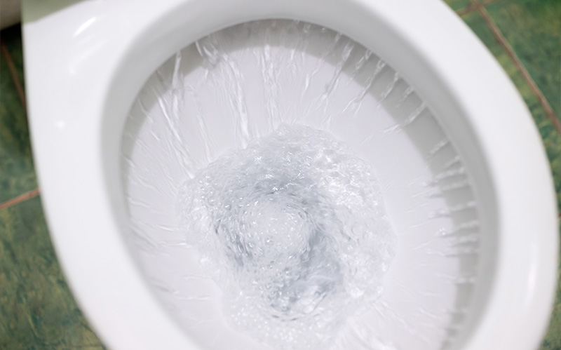 Close-up of a toilet bowl overflowing with water
